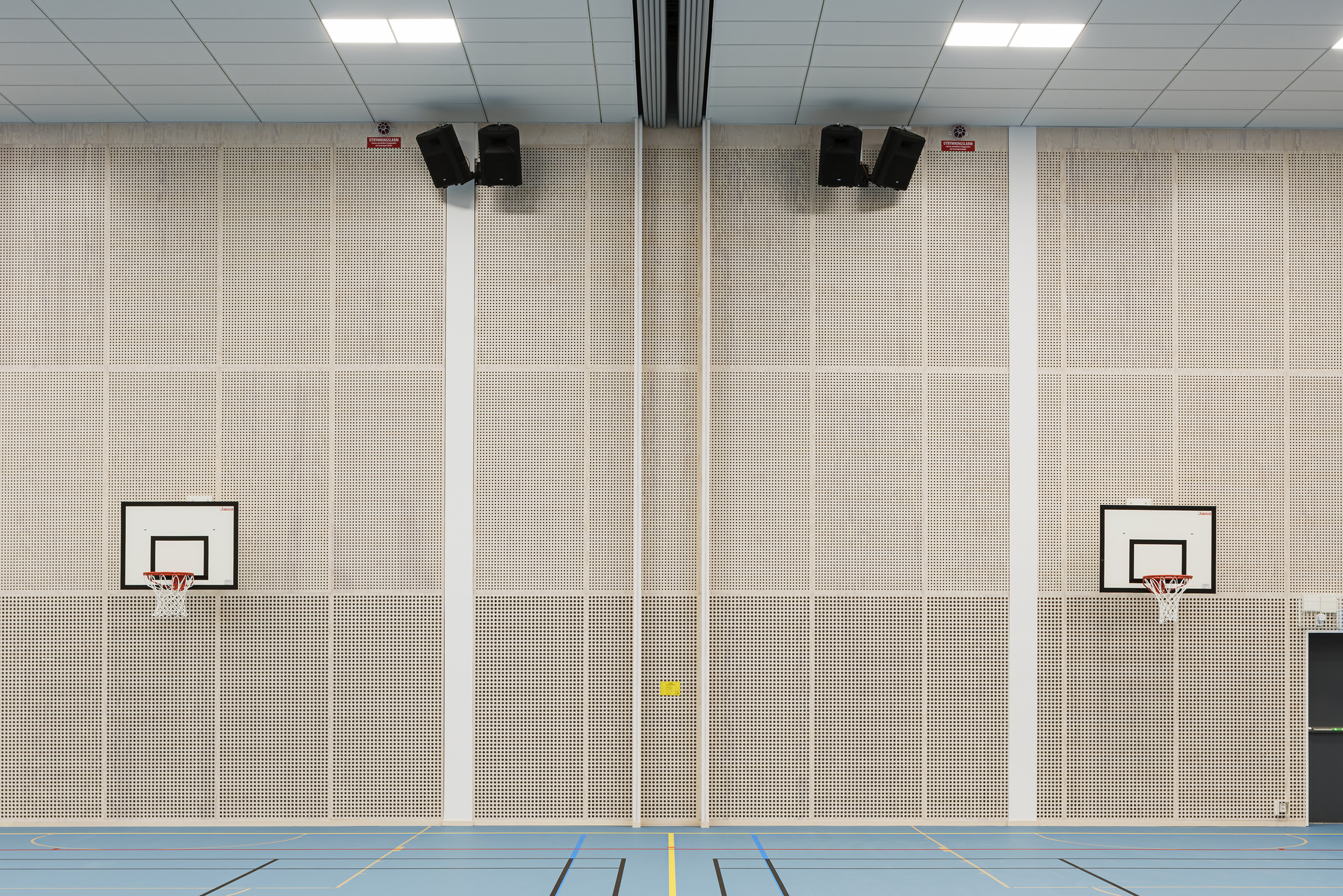 Perforerede træpaneler på væg og basketballkurve
