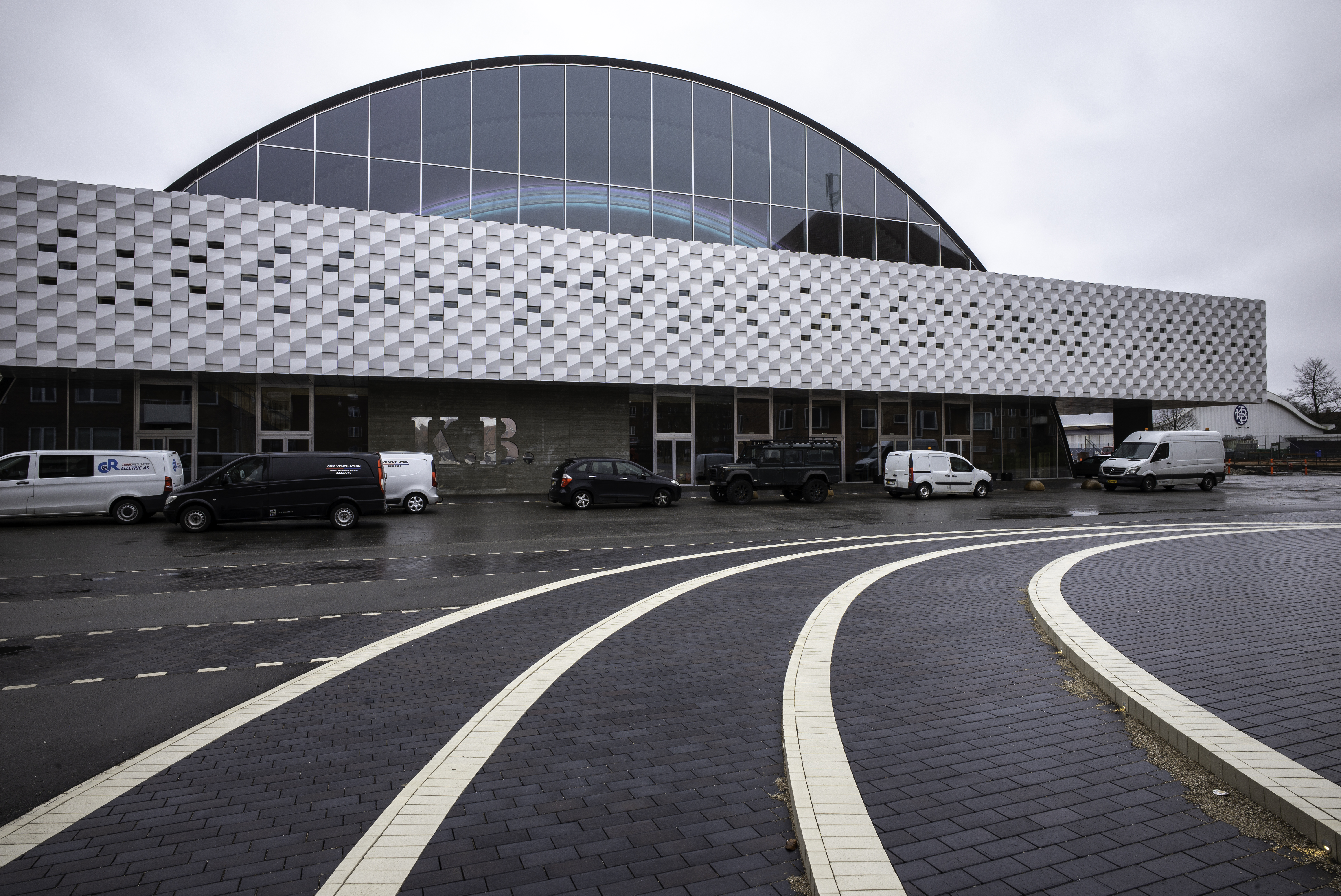 Rundet glasbygning med hvid tilbygning foran